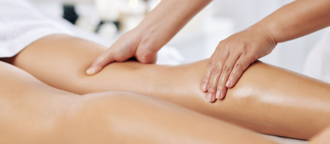 Hands,Of,Massage,Therapist,Massaging,Legs,Of,Young,Woman,In